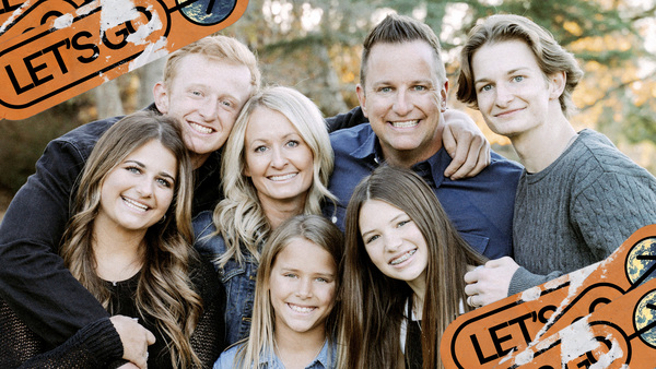 The Fowler family gathers in close and smiles.
