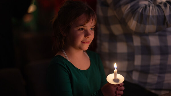 A girl smiling and holding a candle